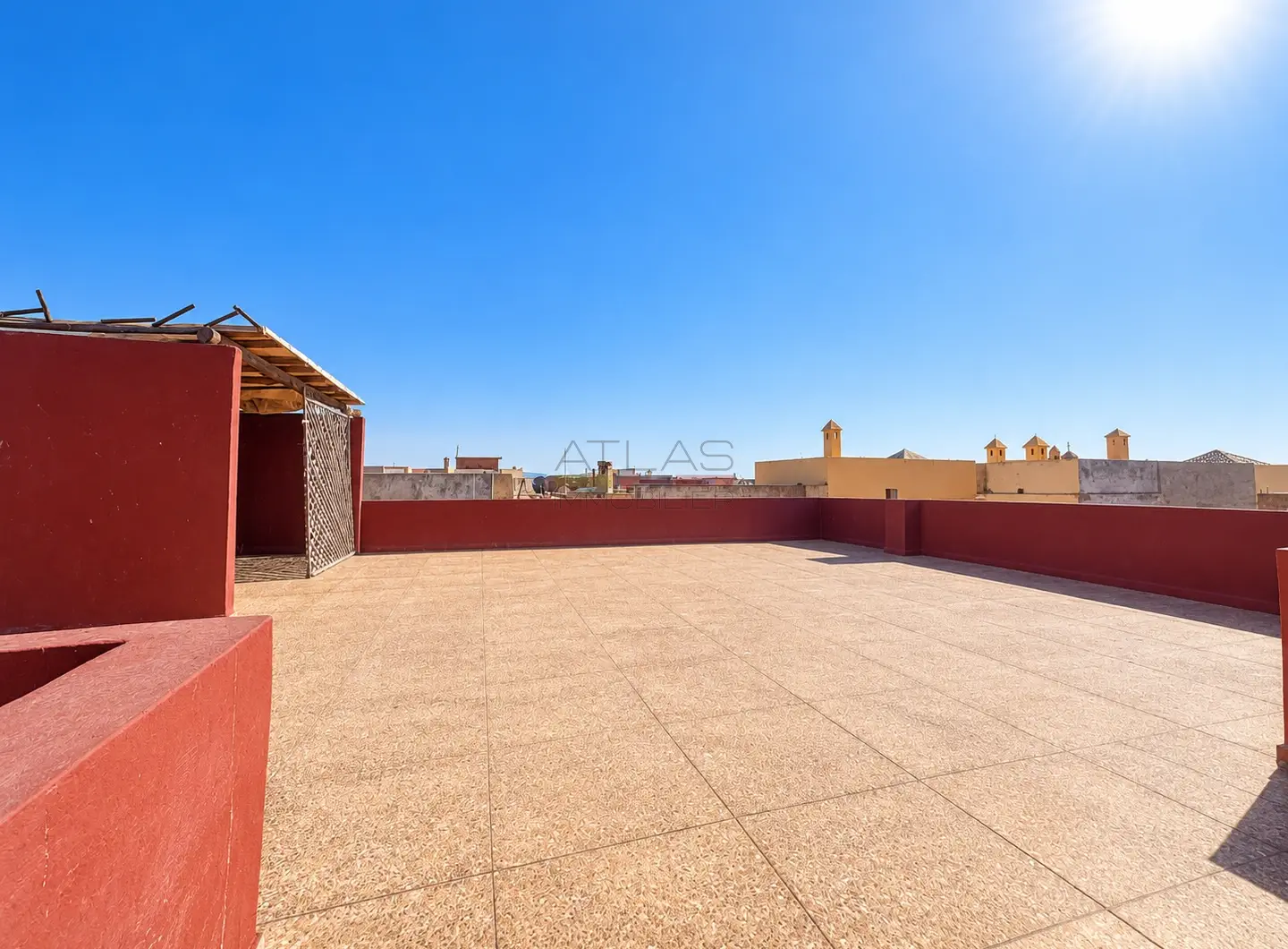 Grande terrasse dégagée d’un appartement à Essaouira avec vue sur les toits de la ville.